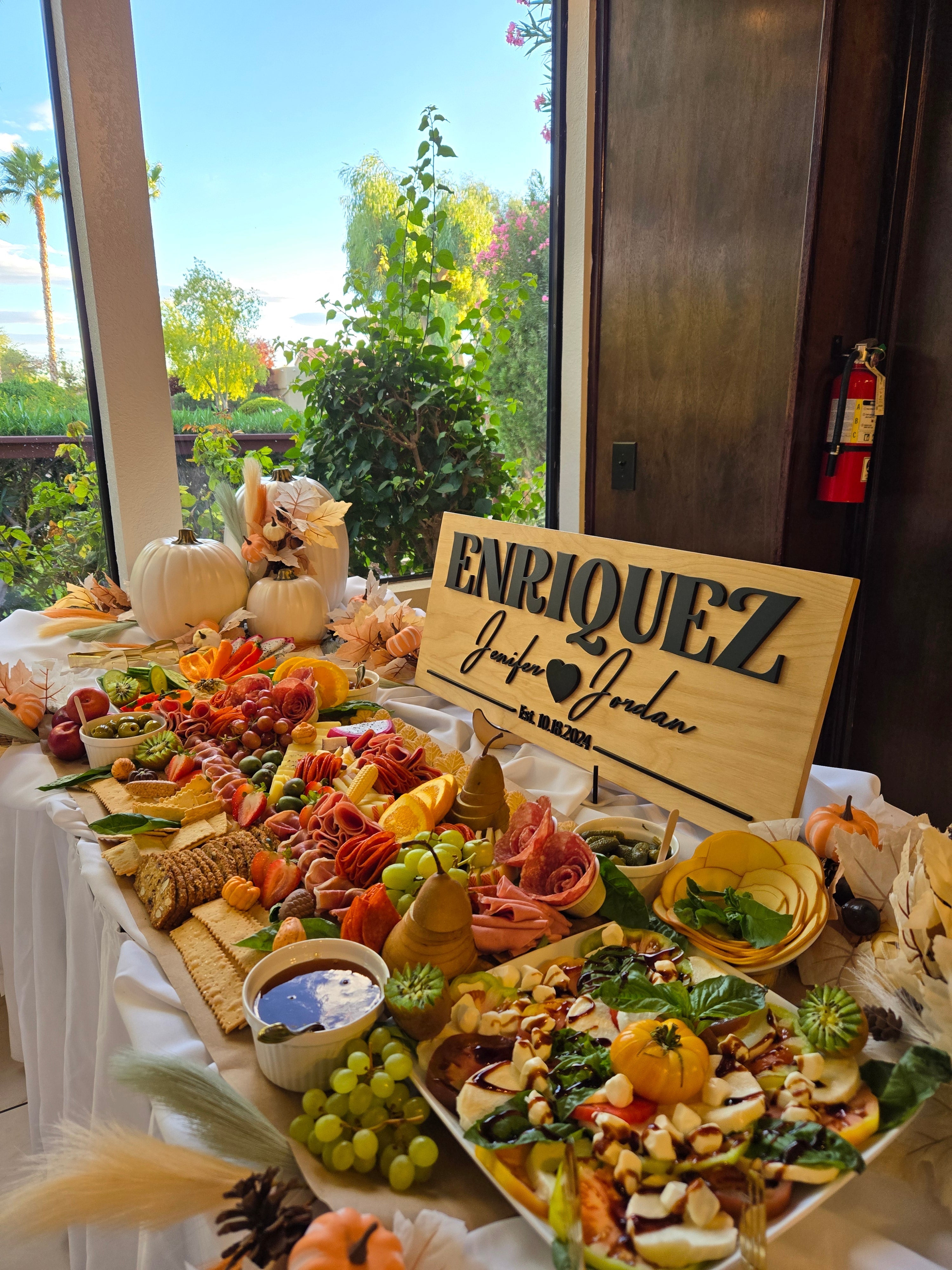 Custom Enriquez wedding grazing table with charcuterie, cheeses, and autumn decor.