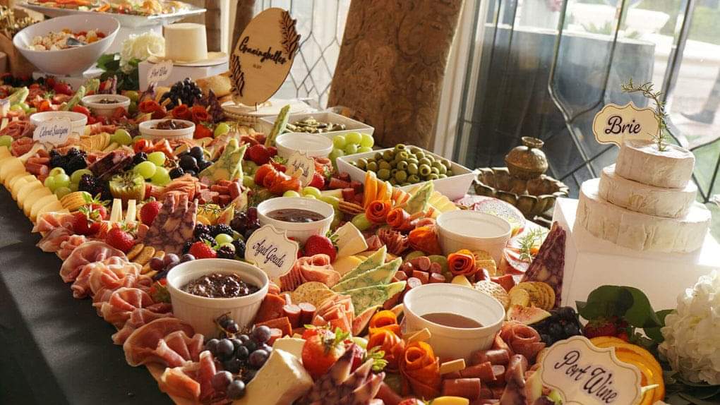 Luxury charcuterie grazing table with assorted cheeses, meats, fruits, and olives for catering.