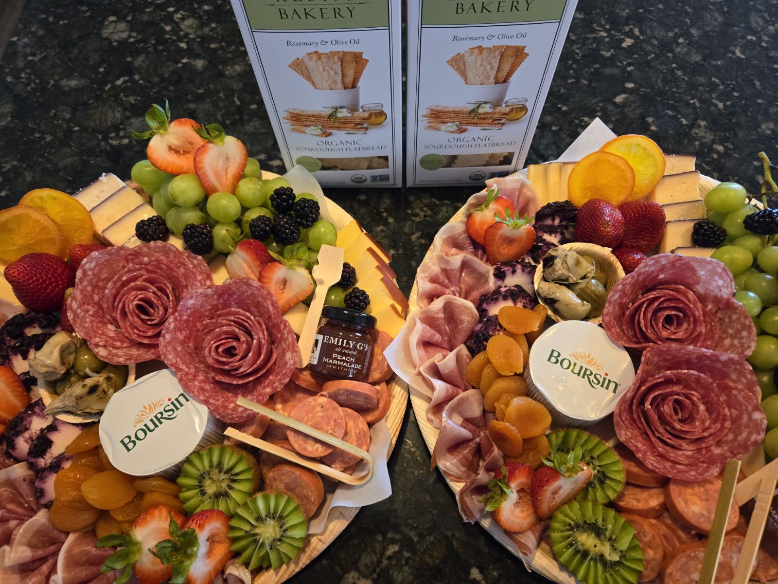 Two gourmet charcuterie boards with salami roses, assorted fruits, cheeses, and crackers.